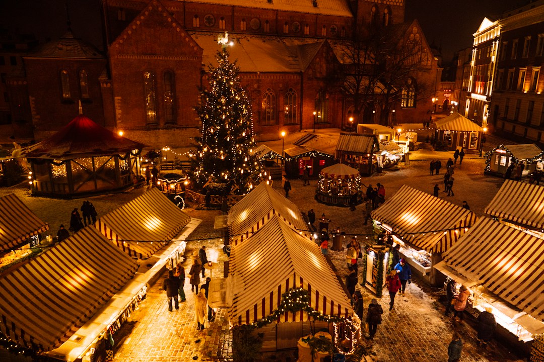 A village lit up with Christmas lights and market stalls on a winter evening near the Peak District